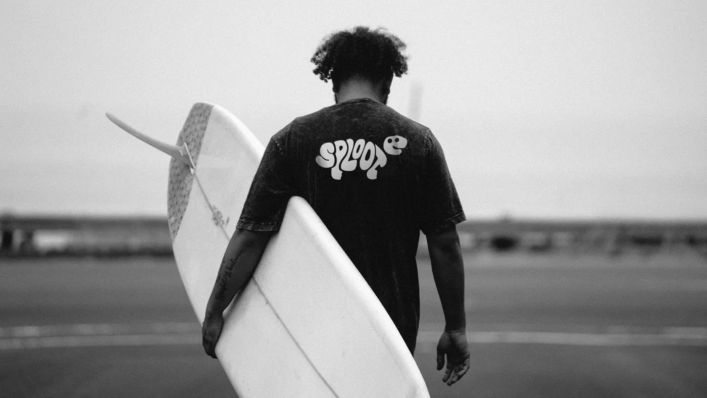 Back view of a black Sploot t-shirt with a surfboard print