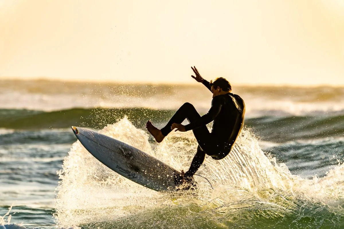 A surfer gliding inside a clear blue barrel