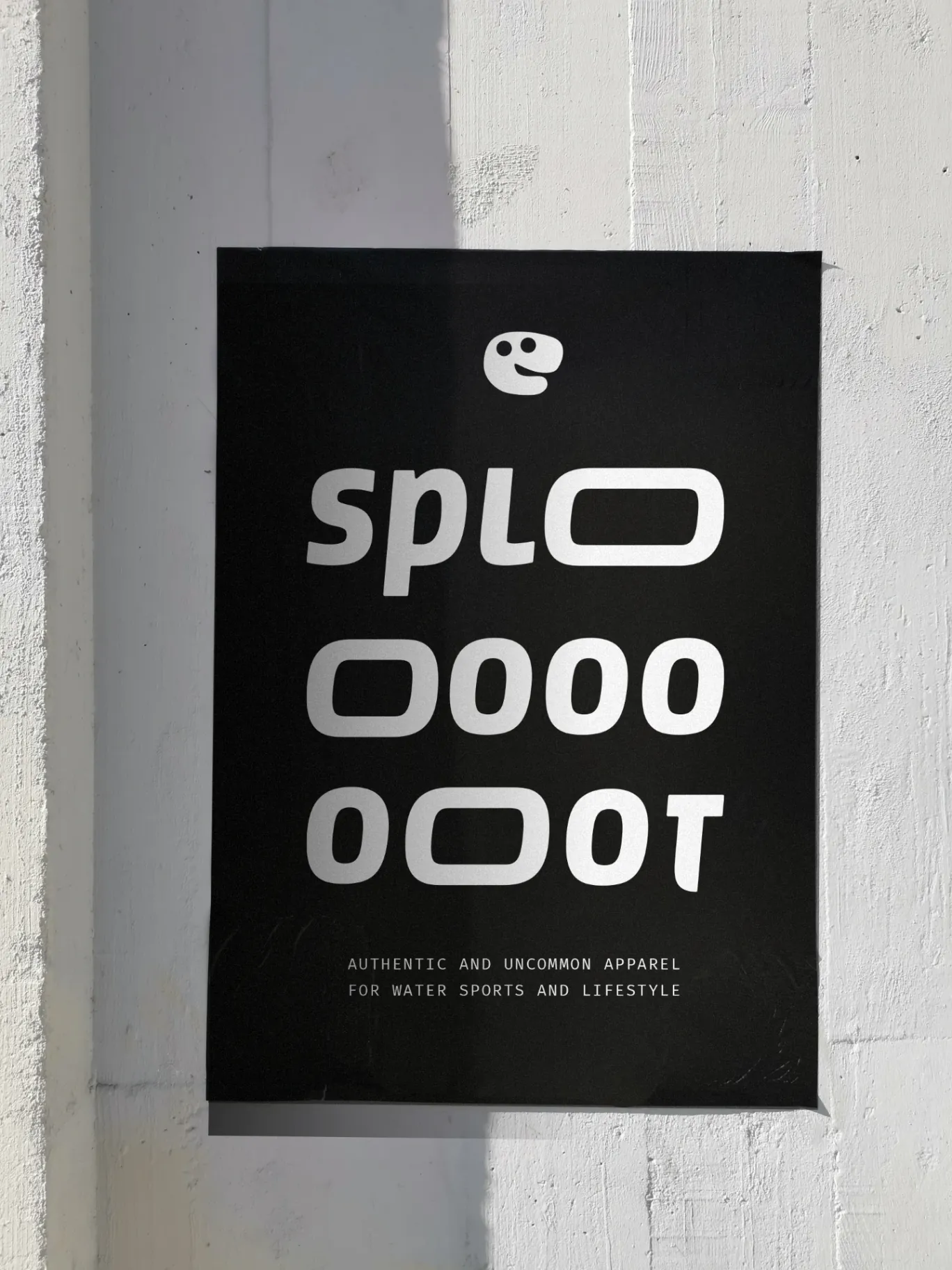 A black splooooot poster pasted on a concrete wall