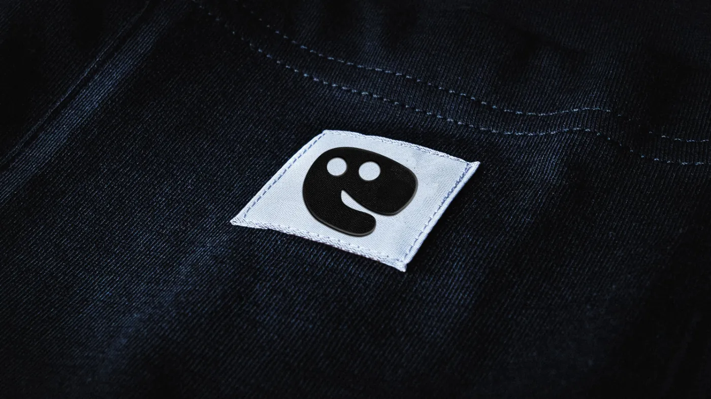 Woven label with the Sploot turtle on a black t-shirt